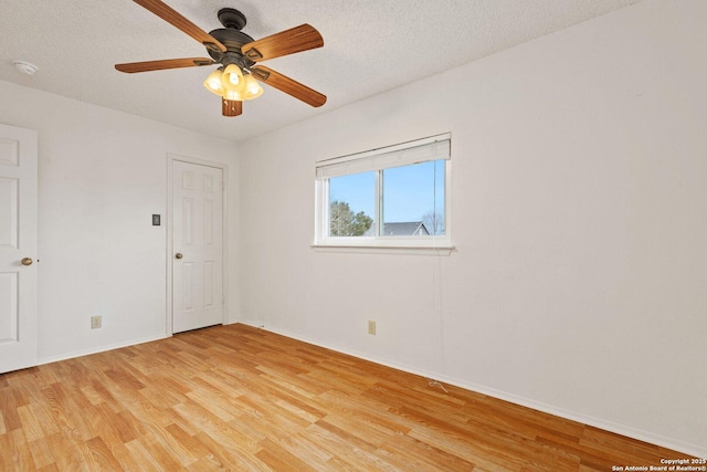 unfurnished room with a textured ceiling, ceiling fan, and light wood-type flooring