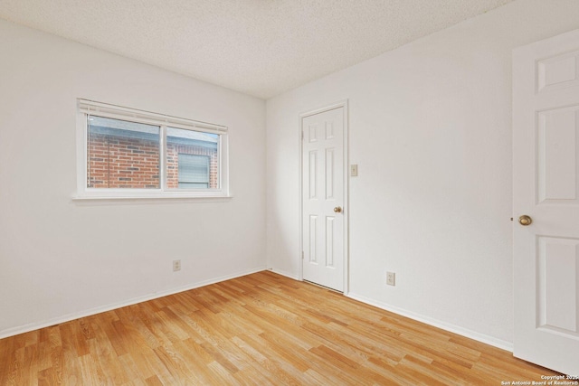 spare room with hardwood / wood-style flooring and a textured ceiling