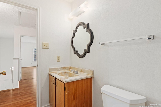 bathroom featuring toilet, hardwood / wood-style flooring, and vanity