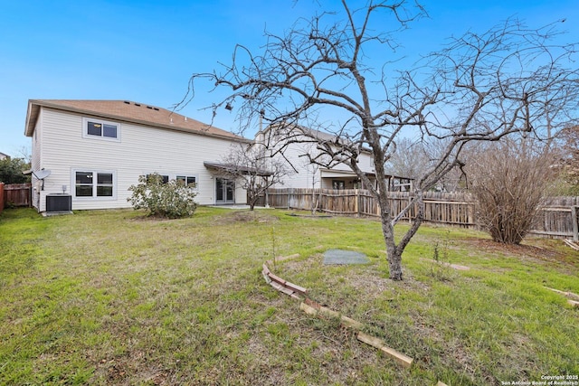 rear view of property with a yard and central AC