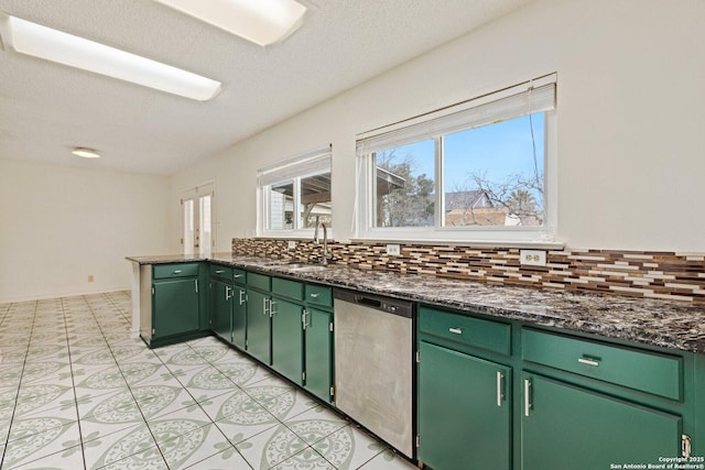 kitchen with dark stone counters, dishwasher, green cabinetry, and tasteful backsplash