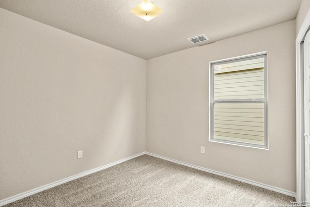 unfurnished room featuring carpet and a textured ceiling