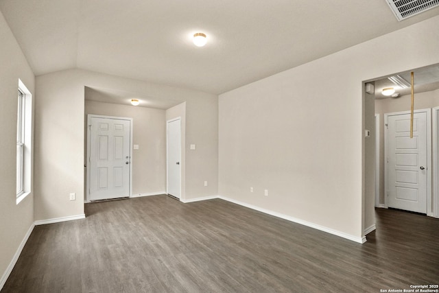 empty room featuring dark wood-type flooring and vaulted ceiling