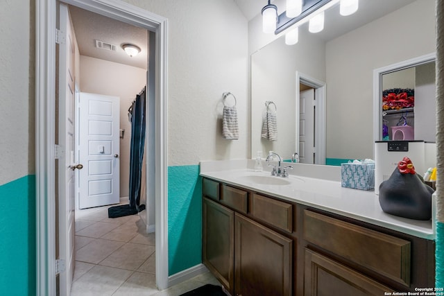 bathroom featuring tile patterned flooring, vanity, and a textured ceiling