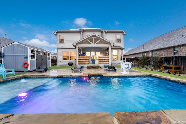 view of swimming pool with a storage shed and a patio area