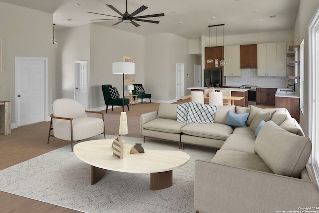 living room featuring light hardwood / wood-style floors, ceiling fan, and sink