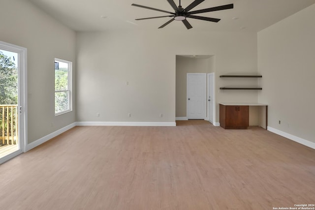 unfurnished living room with a ceiling fan, light wood-style flooring, and baseboards