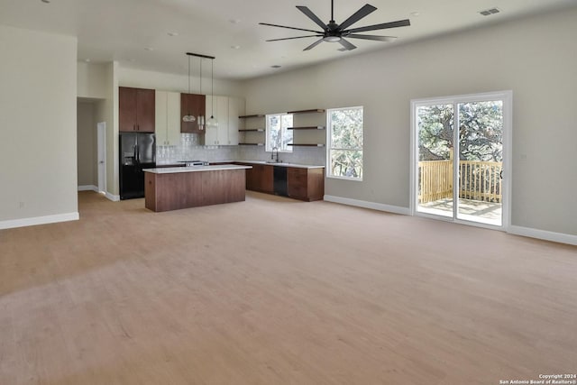 kitchen with a center island, open shelves, visible vents, black refrigerator with ice dispenser, and open floor plan