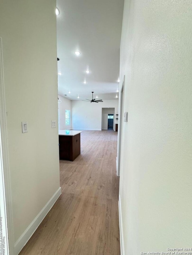 corridor featuring recessed lighting, light wood-type flooring, and baseboards