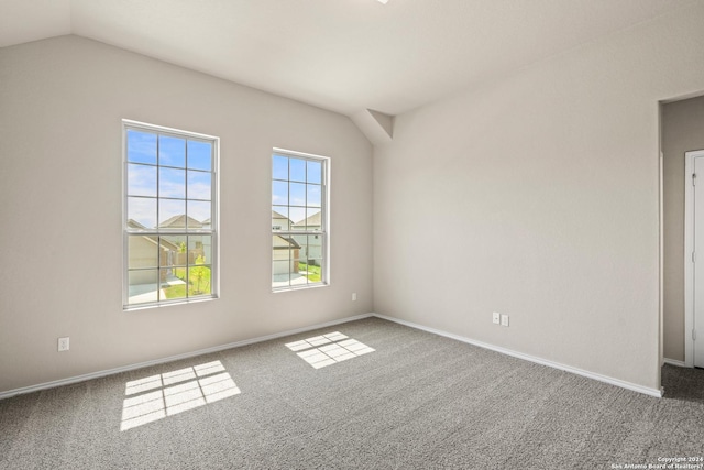 carpeted spare room featuring lofted ceiling