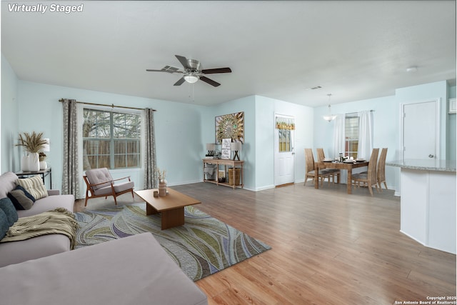 living room featuring light hardwood / wood-style floors and ceiling fan