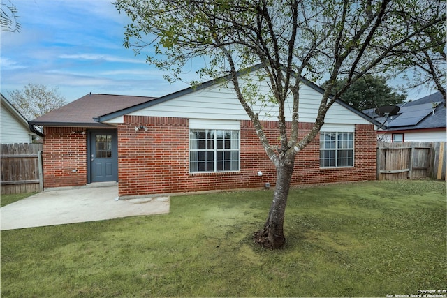 back of house with a lawn and a patio