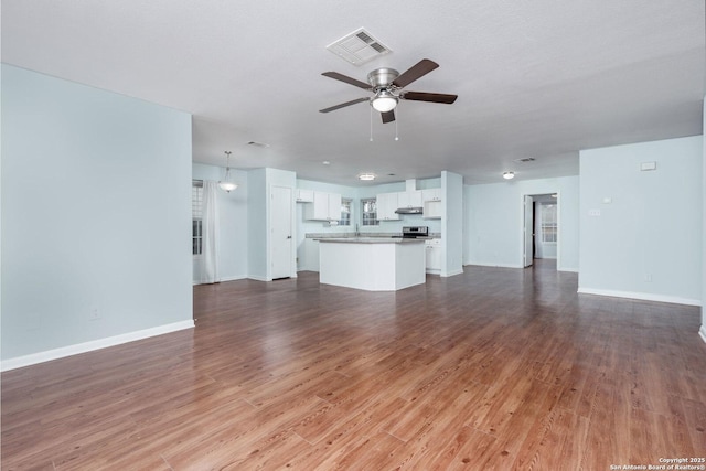 unfurnished living room featuring hardwood / wood-style flooring and ceiling fan