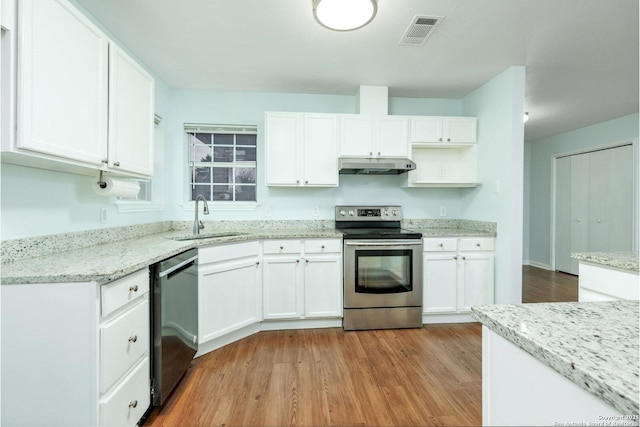 kitchen featuring white cabinets, sink, light wood-type flooring, appliances with stainless steel finishes, and light stone counters