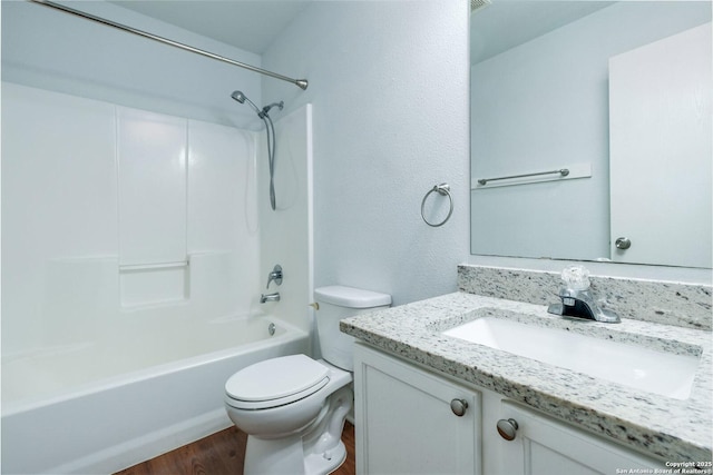 full bathroom featuring hardwood / wood-style floors, vanity, toilet, and shower / washtub combination