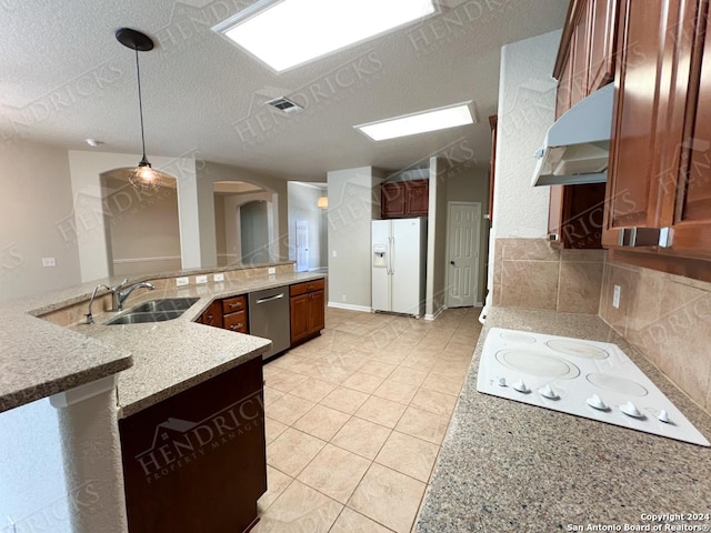 kitchen with pendant lighting, white appliances, ventilation hood, sink, and a textured ceiling