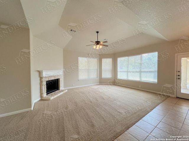 unfurnished living room featuring lofted ceiling, ceiling fan, light tile patterned floors, a textured ceiling, and a fireplace