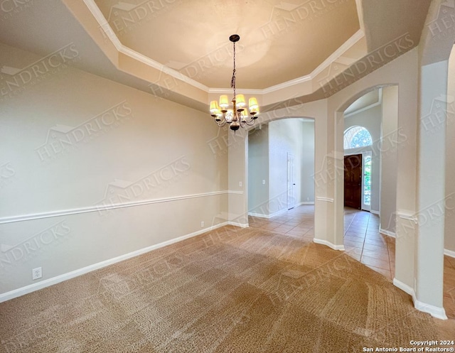 tiled spare room with crown molding and a chandelier