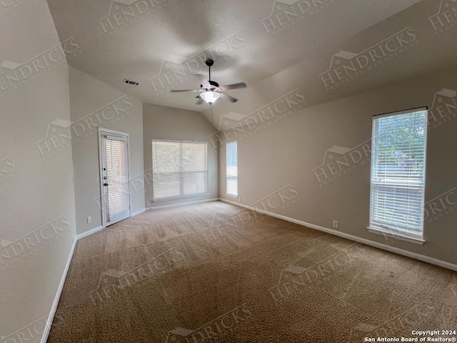 carpeted empty room featuring ceiling fan and vaulted ceiling