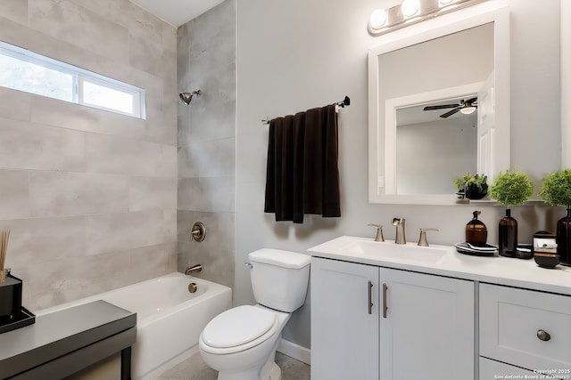 full bathroom featuring tiled shower / bath, vanity, and toilet