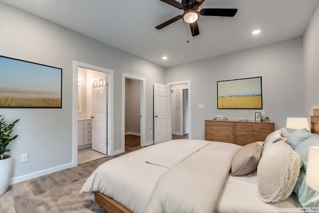 bedroom with ensuite bathroom, ceiling fan, and light hardwood / wood-style floors