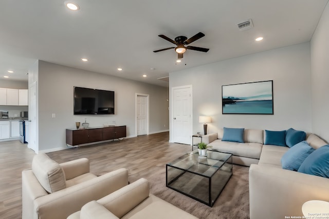 living room with light hardwood / wood-style floors and ceiling fan