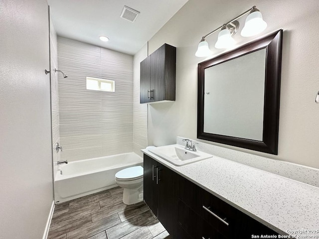 full bathroom with vanity, toilet, and tiled shower / bath combo