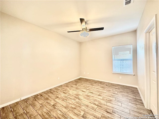 empty room with ceiling fan and light hardwood / wood-style flooring