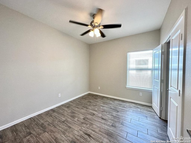 spare room with dark hardwood / wood-style floors and ceiling fan