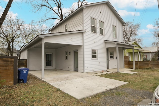 rear view of house featuring a lawn and a patio area