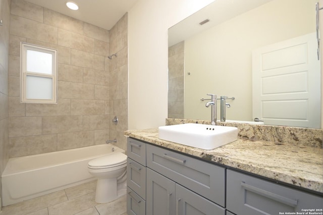 full bathroom featuring tile patterned floors, vanity, toilet, and tiled shower / bath combo