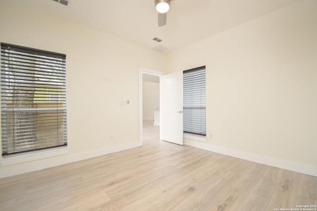 empty room with ceiling fan and light hardwood / wood-style floors