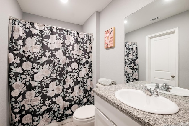 bathroom featuring toilet, a shower with shower curtain, and vanity