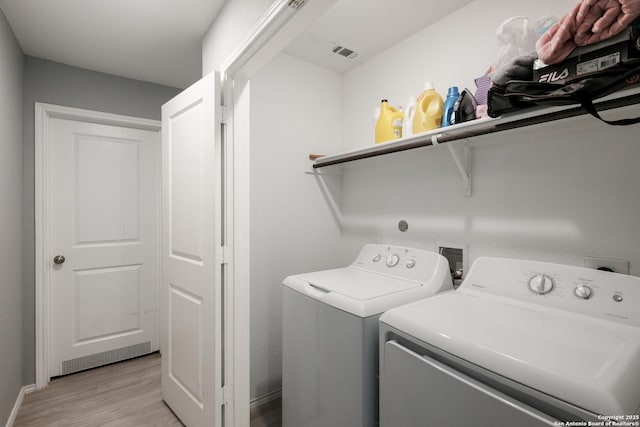 laundry room with light hardwood / wood-style floors and independent washer and dryer