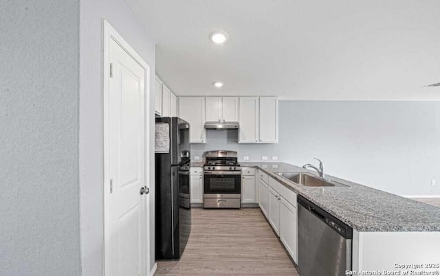 kitchen with sink, white cabinetry, appliances with stainless steel finishes, and light wood-type flooring