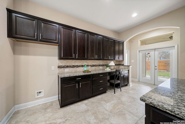 kitchen featuring backsplash, light stone counters, dark brown cabinets, and french doors