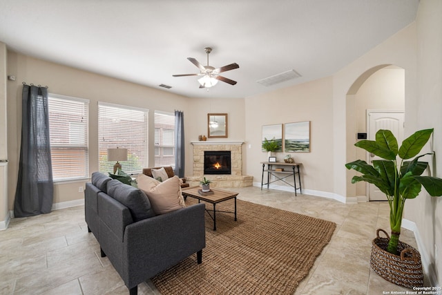 living room featuring ceiling fan and a fireplace