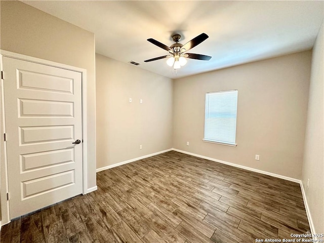 unfurnished room featuring dark hardwood / wood-style flooring and ceiling fan