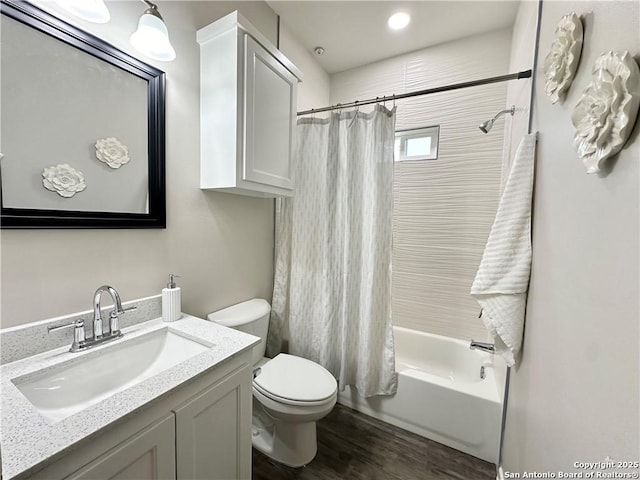 full bathroom with shower / bathtub combination with curtain, hardwood / wood-style floors, vanity, and toilet