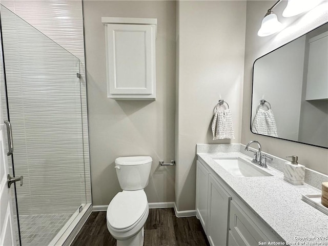 bathroom featuring vanity, toilet, wood-type flooring, and a tile shower