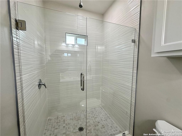 bathroom with an enclosed shower and toilet