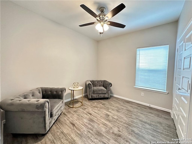 living area with hardwood / wood-style flooring and ceiling fan