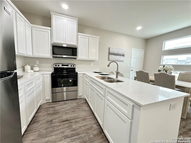 kitchen with light stone counters, white cabinetry, sink, and appliances with stainless steel finishes