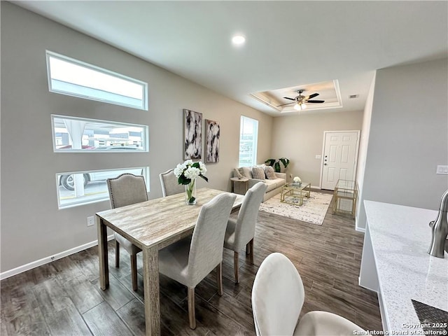 dining space featuring ceiling fan, dark hardwood / wood-style flooring, and a tray ceiling