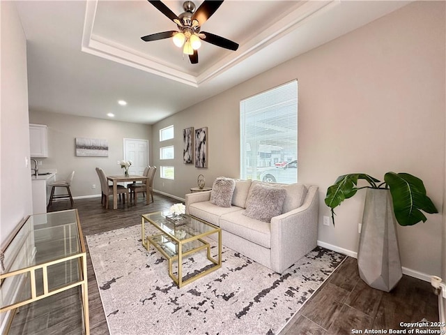 living room featuring ceiling fan, sink, and a tray ceiling