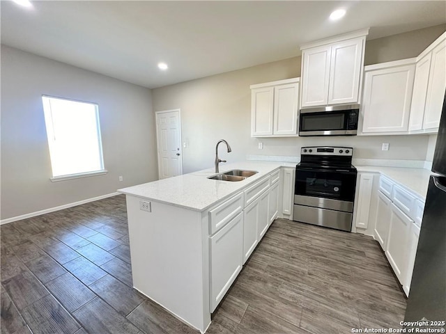 kitchen featuring light stone countertops, sink, kitchen peninsula, white cabinets, and appliances with stainless steel finishes