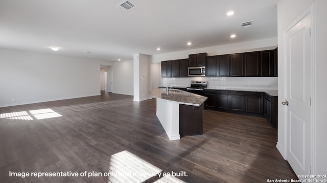 kitchen featuring light stone countertops, dark hardwood / wood-style flooring, an island with sink, decorative backsplash, and appliances with stainless steel finishes