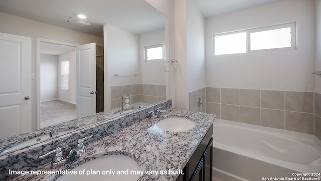 bathroom featuring a tub to relax in and vanity