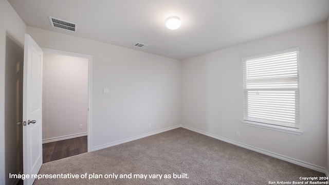 spare room with dark colored carpet