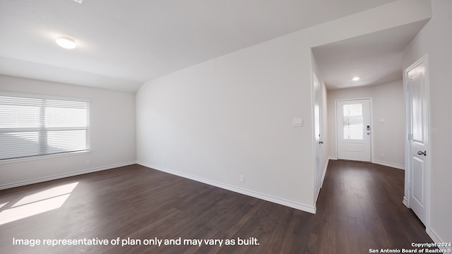 spare room with dark hardwood / wood-style floors, plenty of natural light, and lofted ceiling